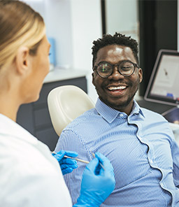 Smiling man discussing treatment with dentist 